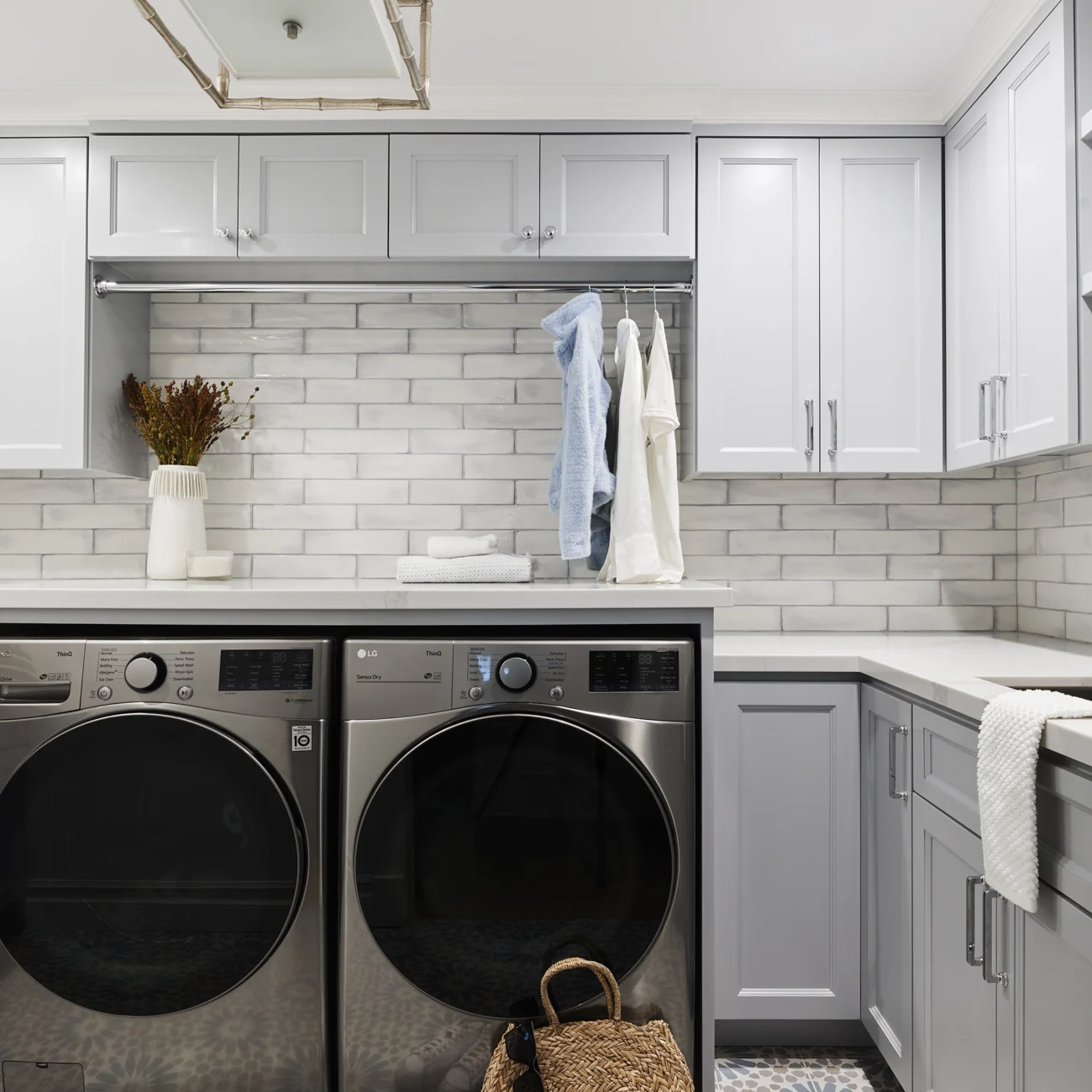 Christine Vroom Interiors Vigilance | Laundry room with light grey cabinets and high-end appliances