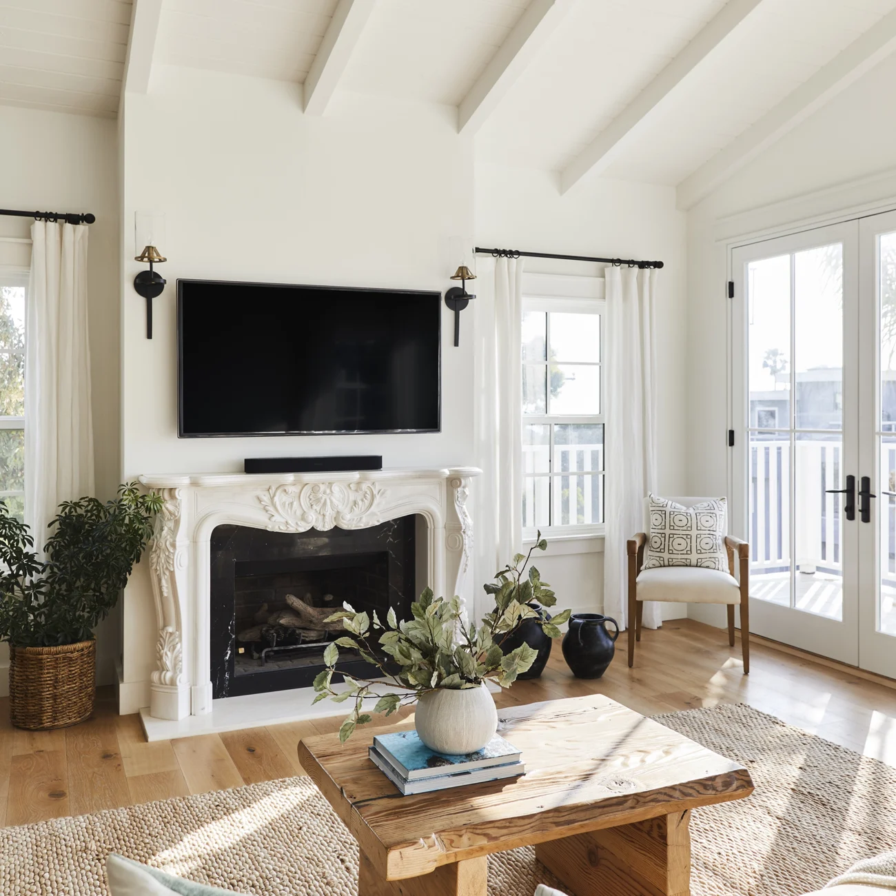 Christine Vroom Interiors | Gentry | Bright, white living room with vaulted ceilings and molded fireplace encasement