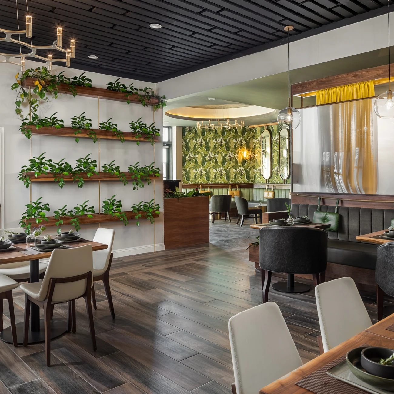 Christine Vroom Interiors Pacific Standard | Contemporary Restaurant Interior with plants, green print wallpaper, gold and black accents and wood floors