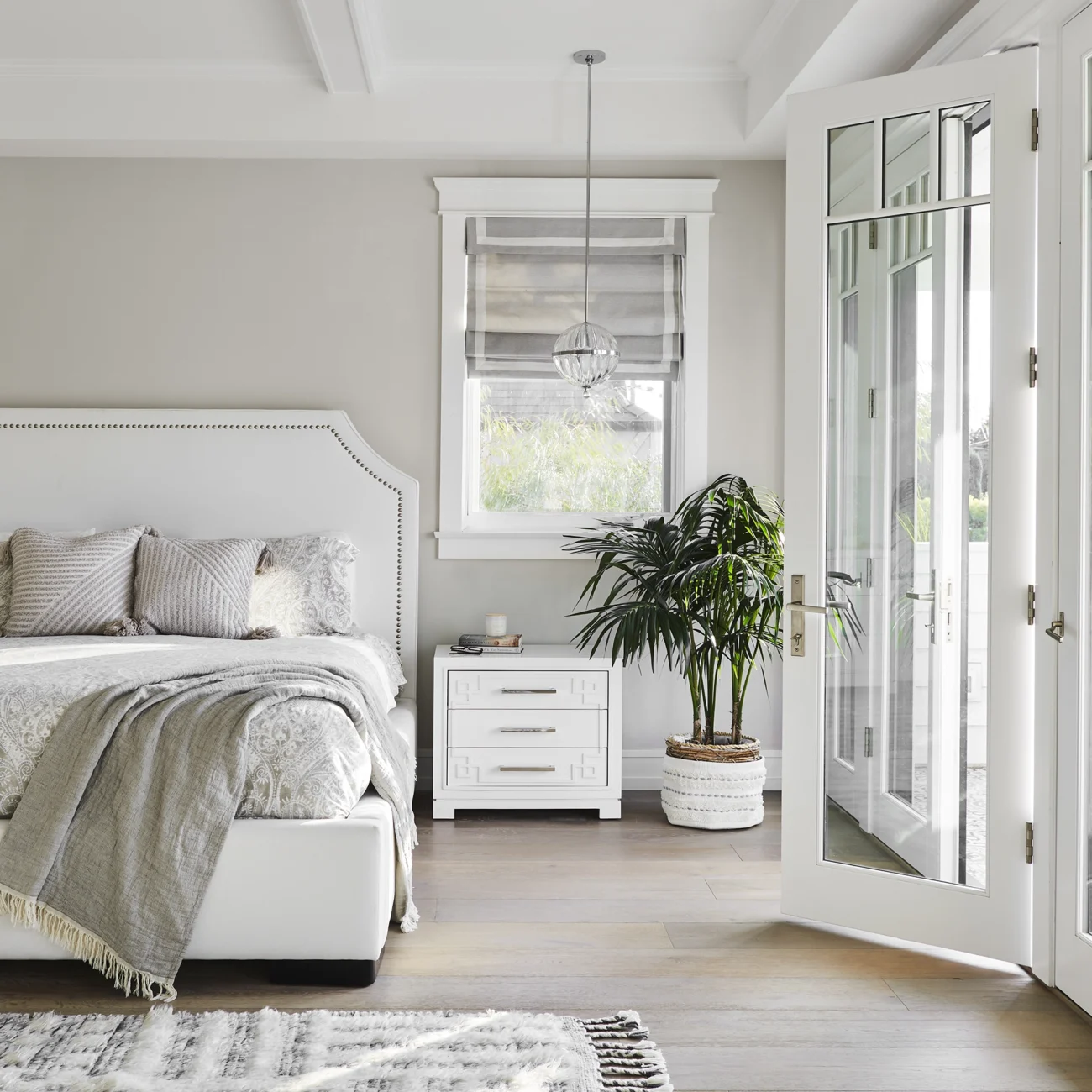 Christine Vroom-Interiors Thayer | Traditional bedroom with vaulted ceiling and french doors leading to backyard doors