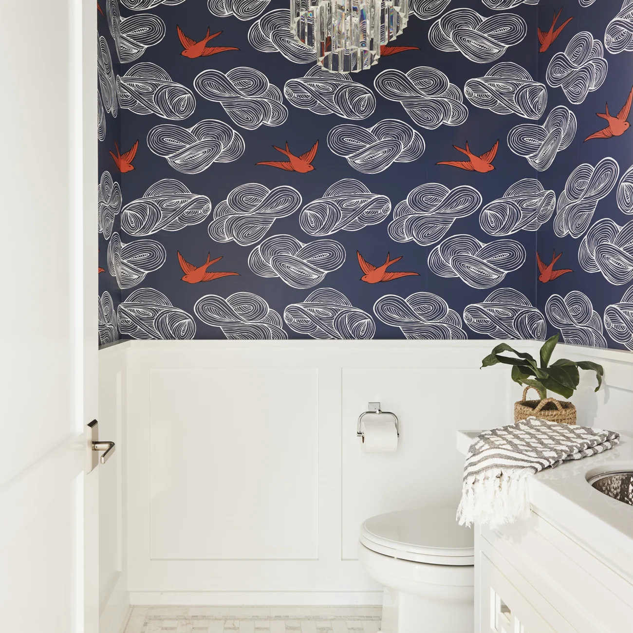 Christine Vroom-Interiors Thayer | Traditional powder room with white fixtures and whimsical navy and red wallpaper