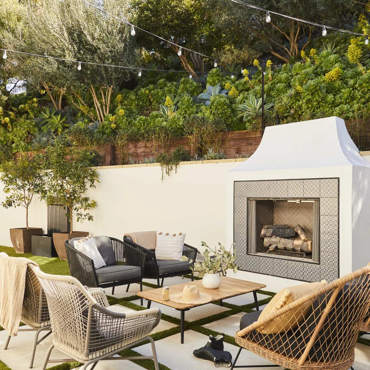 Christine Vroom Interiors | Via Almar | Costal patio with outdoor fireplace and grass grown in between concrete pads