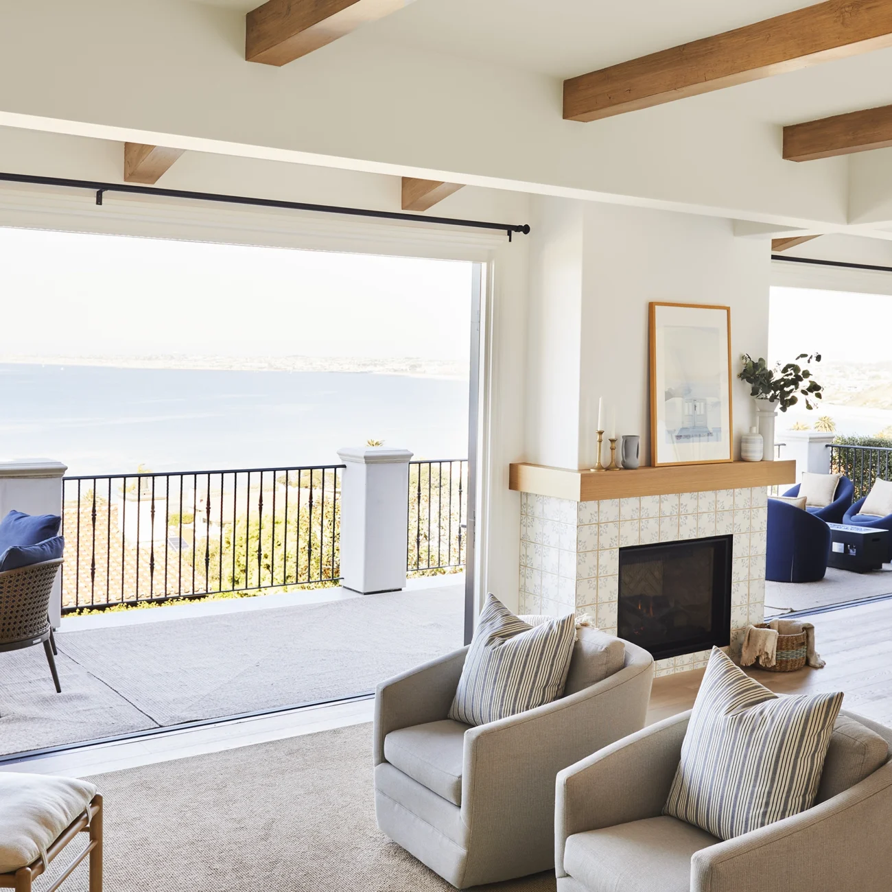 Christine Vroom Interiors | Via Almar | Costal Bright living room with floor to ceiling windows and doors and exposed beams