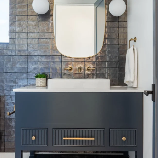 Christine Vroom Interiors | 36th | Costal bathroom with dark blue/grey vanity with gold trim