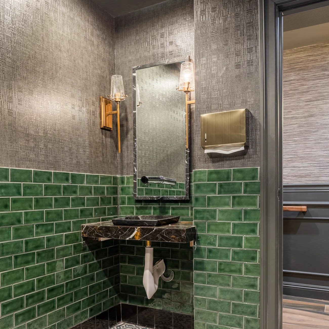 Christine Vroom Interiors Pacific Standard | Contemporary Restaurant Bathroom sink and mirror with green subway tiles and marbled sink