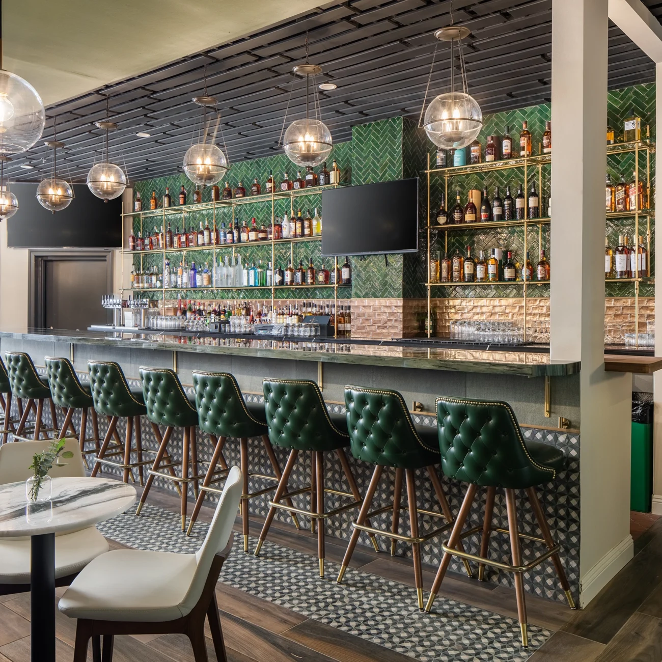 Christine Vroom Interiors Pacific Standard | Contemporary Restaurant Interior deep green leather tufted high chairs at bar