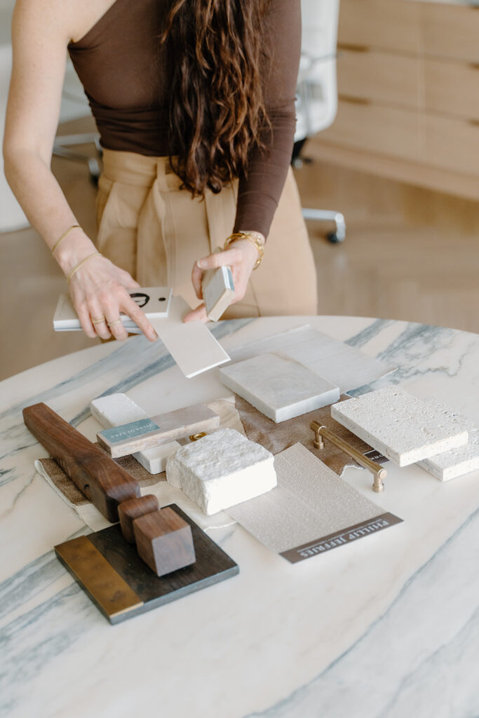 Christine Vroom stands with swatches and samples for a project